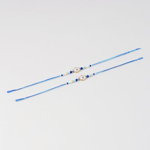 Full-length view of the Handmade White Hamsa Evil Eye Rakhi Set of 2 showing the complete handcrafted design and blue cotton thread.
