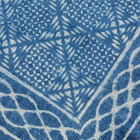 Close-up of geometric hand block printed motifs on an indigo cotton dhurrie, highlighting weave texture and craftsmanship