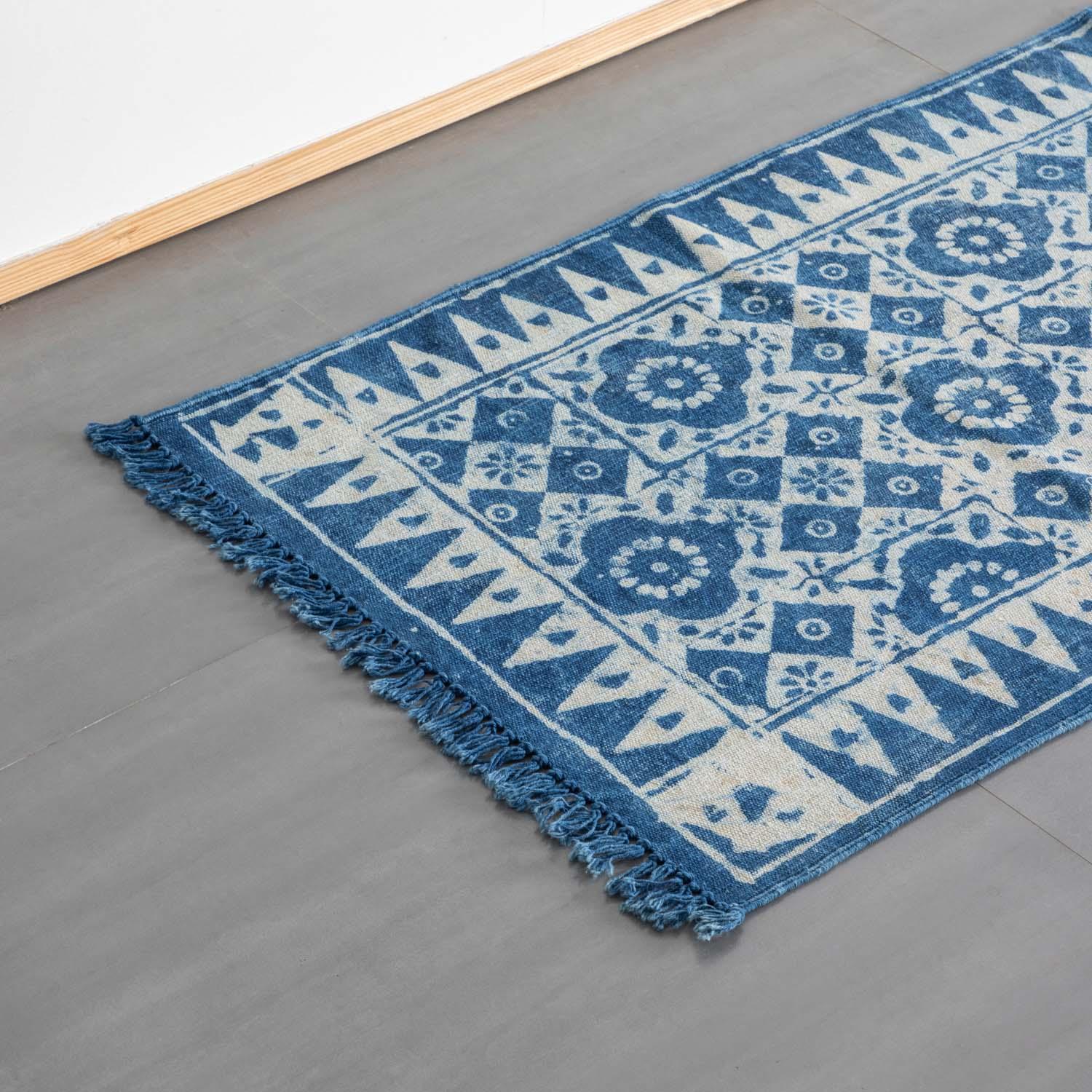 Angled view of a handmade indigo geometric floral cotton dhurrie