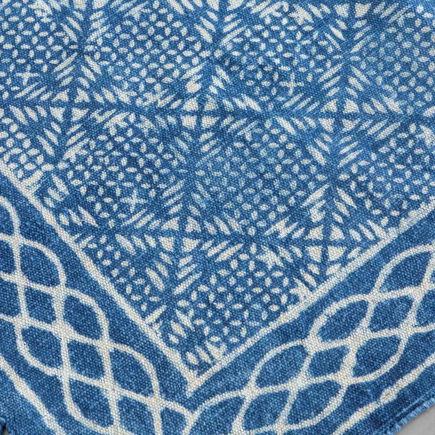 Close-up of geometric block print motifs on an indigo cotton dhurrie rug