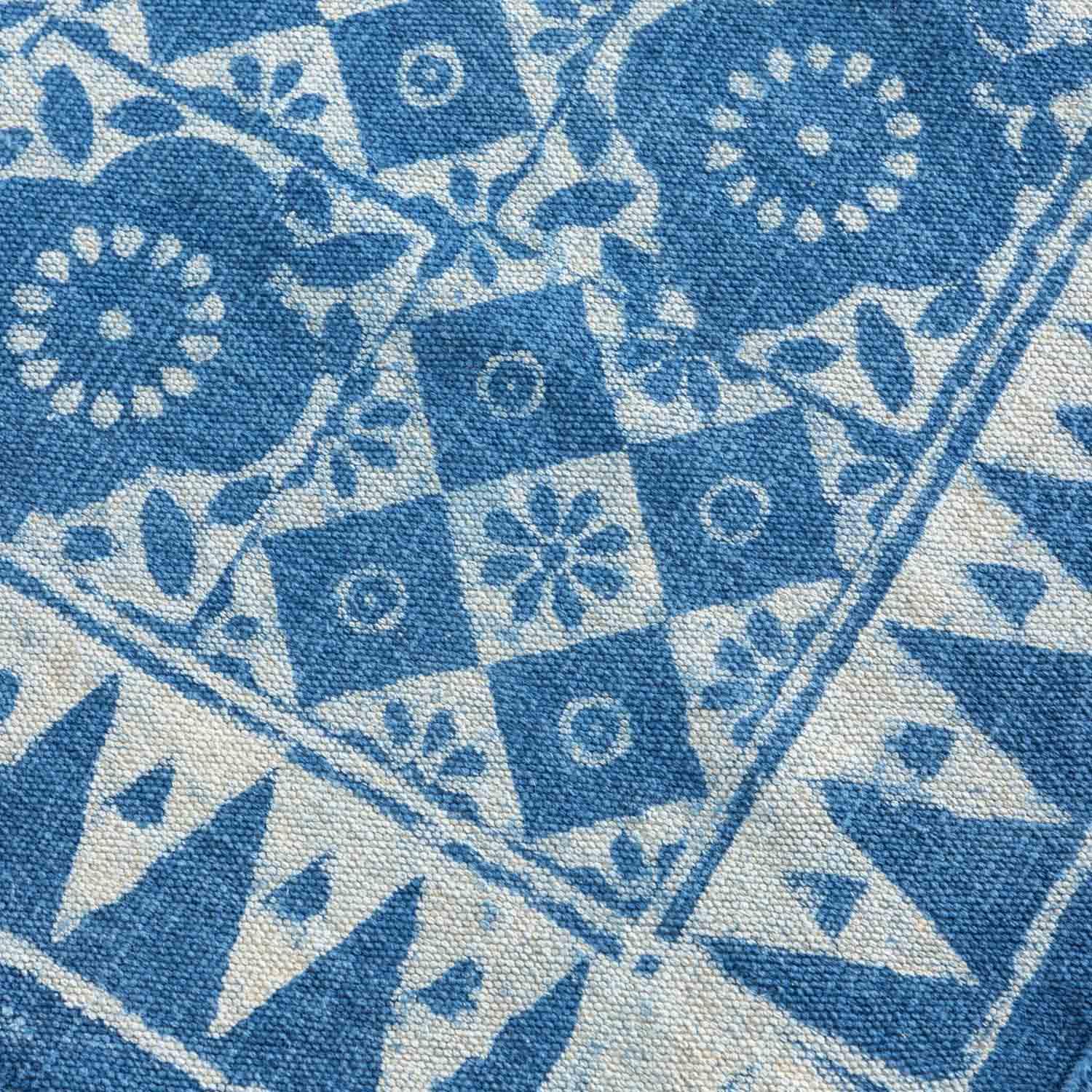 Close-up of geometric floral hand block printed motifs on an indigo cotton dhurrie, highlighting artisan craftsmanship