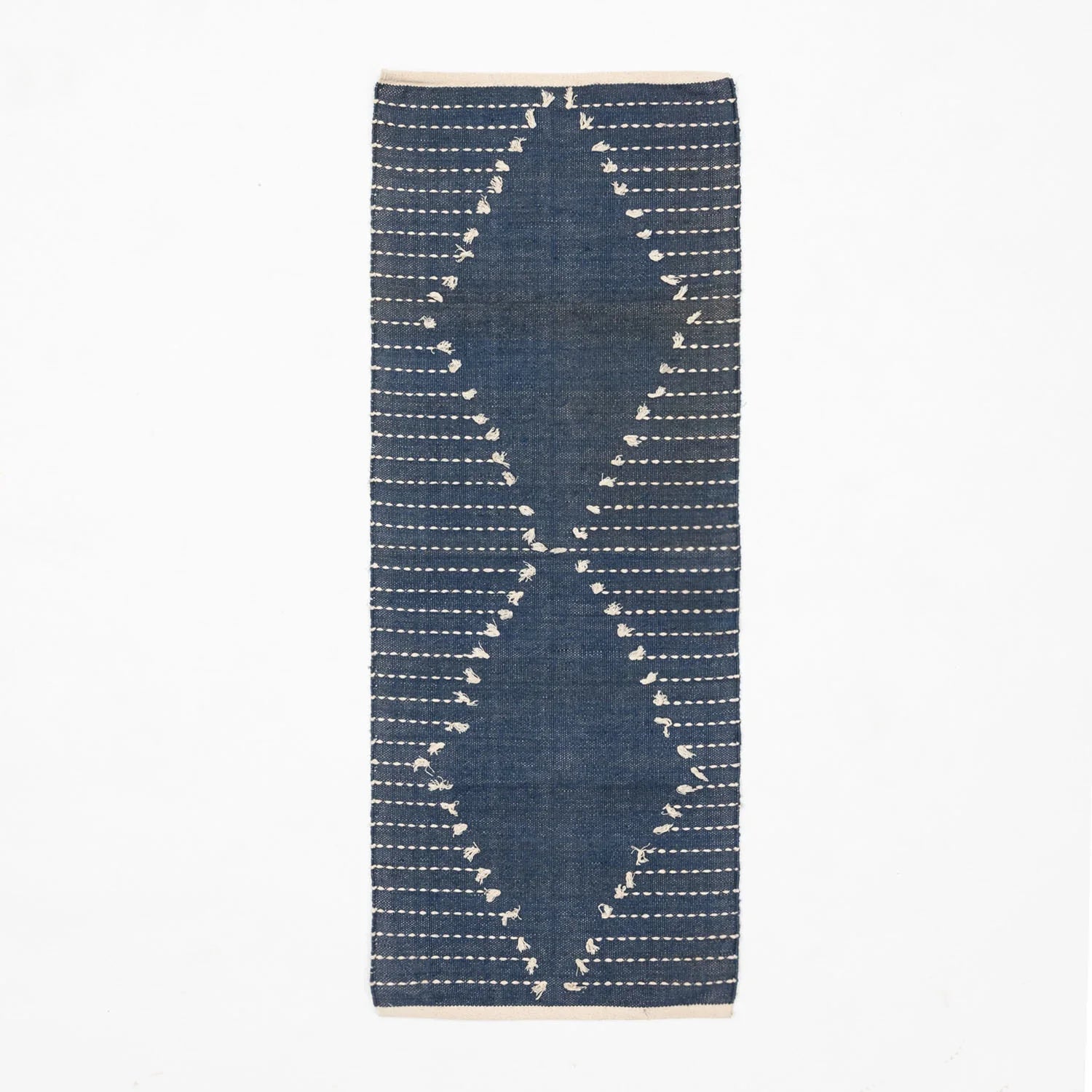 Indigo blue handwoven cotton dhurrie rug featuring white dotted stripe patterns across the surface