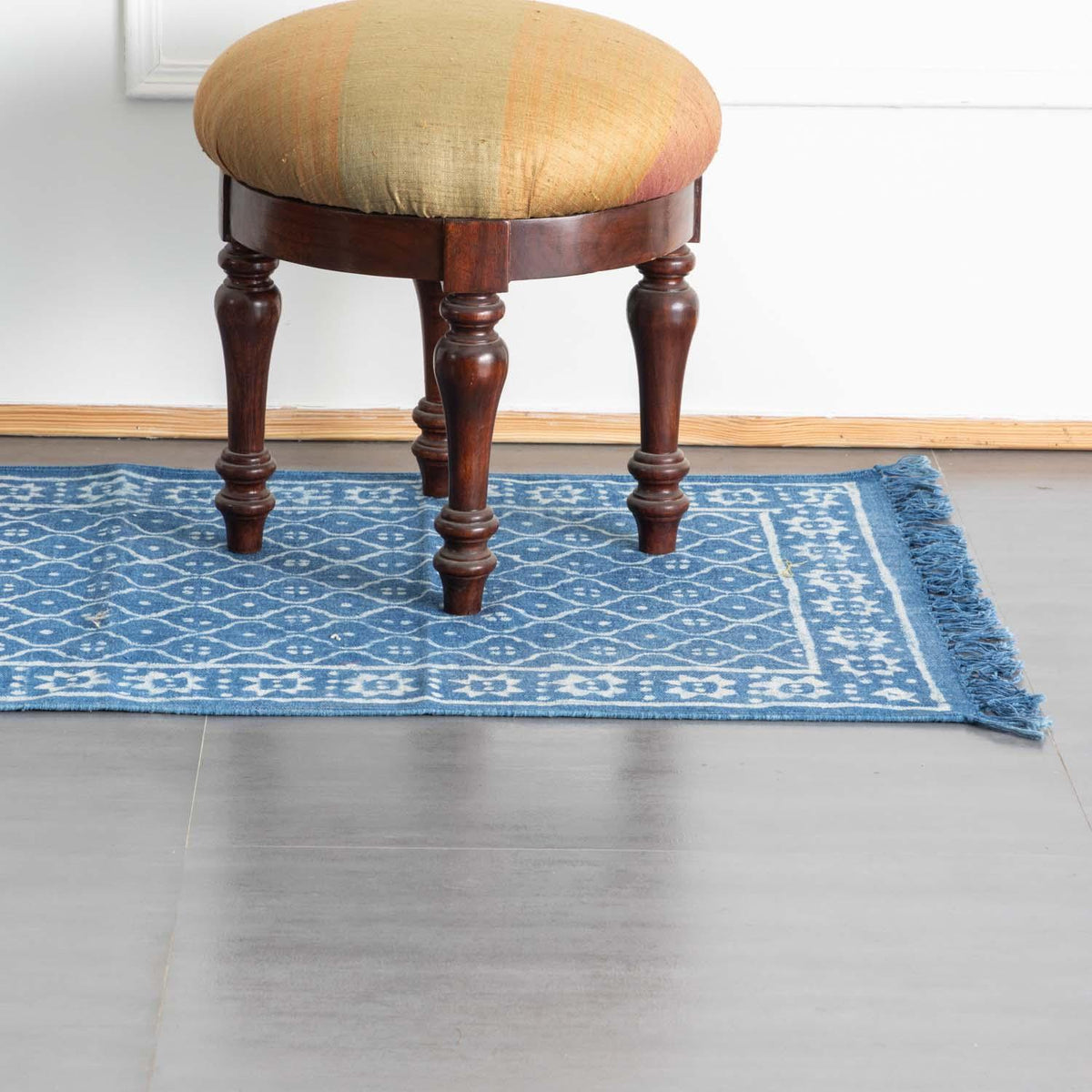 Indigo trellis block printed cotton dhurrie floor rug styled in an entryway, adding handcrafted texture and timeless appeal to the space