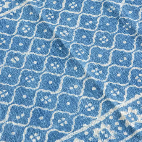 Close-up of trellis hand block printed motifs on an indigo cotton dhurrie highlighting artisan craftsmanship and texture