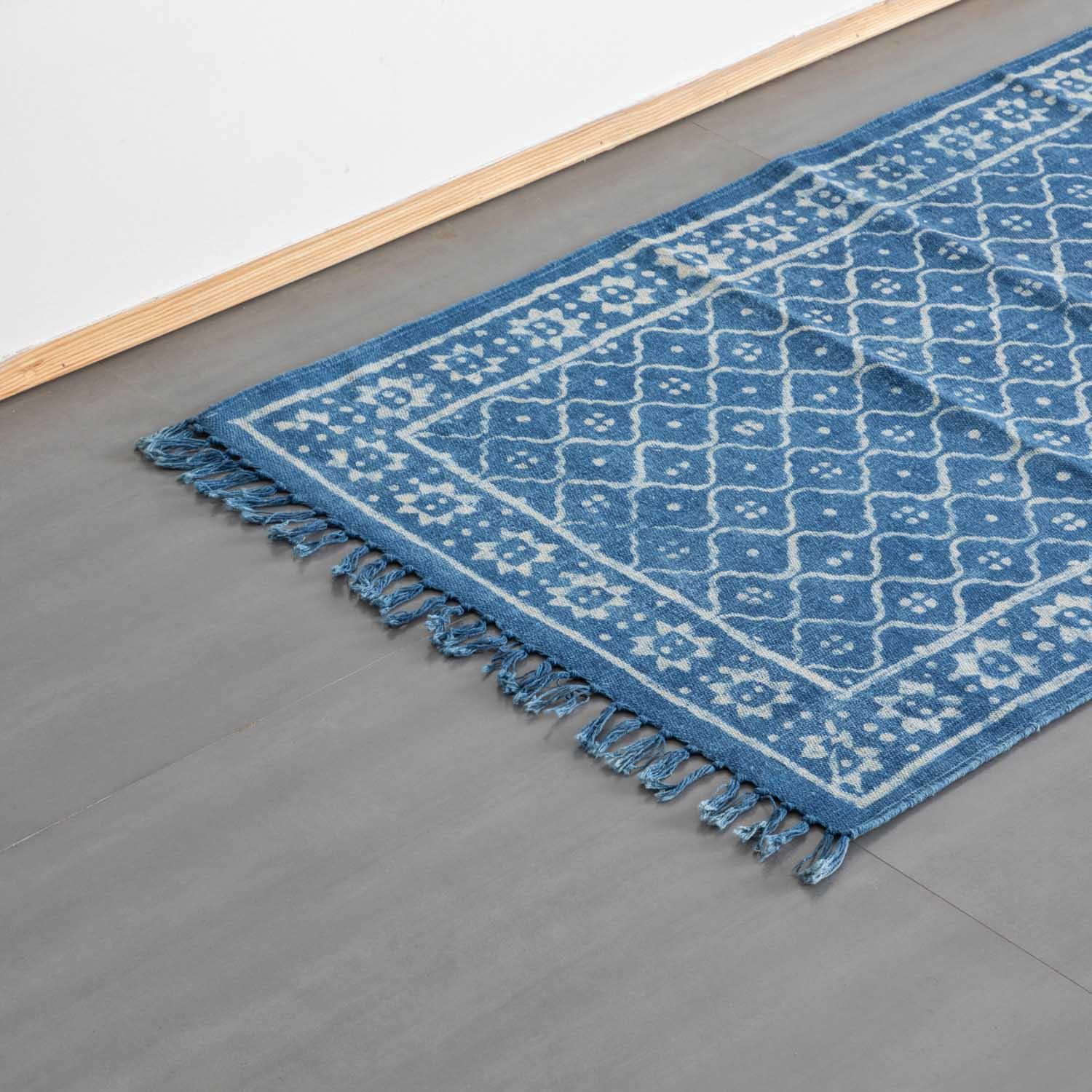 Oblique high-angle view of an indigo trellis block printed dhurrie rug showcasing trellis pattern placement and craftsmanship