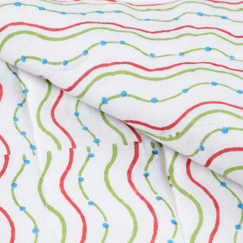 Close-up of hand block-printed cotton quilt fabric highlighting jellyfish and wave designs, soft texture, and artisan craftsmanship