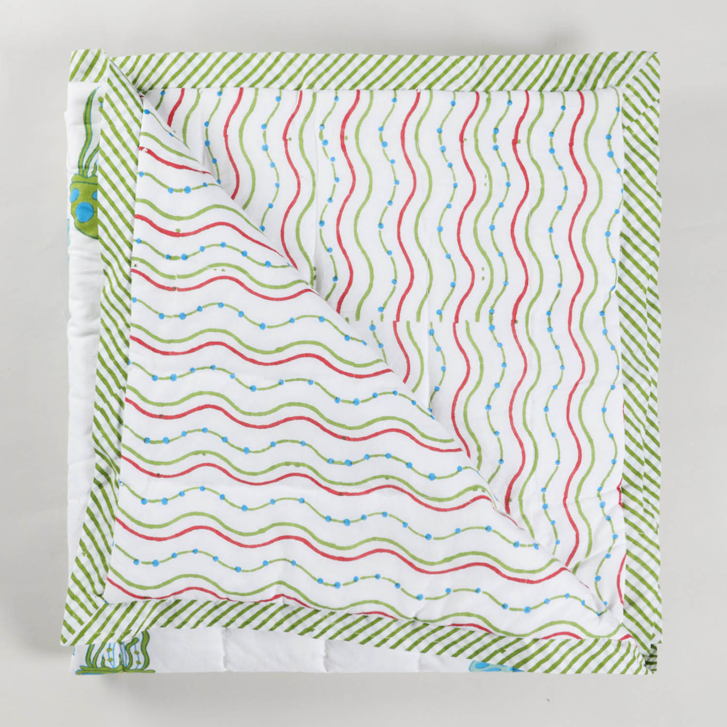Reversible block printed cotton quilt showcasing complementary sea-inspired patterns, lightweight and suitable as an AC quilt or summer blanket