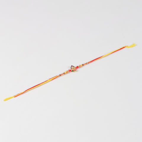 Full-length view of the Handmade Kids Metal Ganesh Rakhi, showcasing the handcrafted design and festive thread.