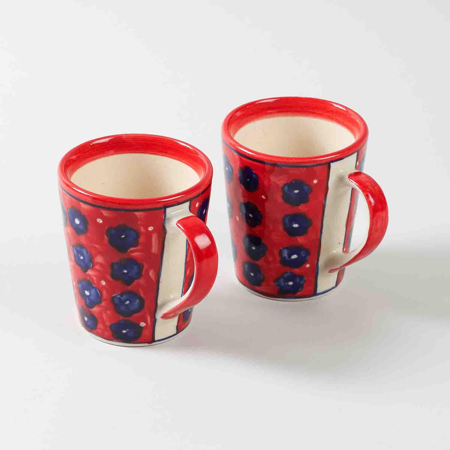 Angled view of large floral red ceramic coffee mugs showcasing handcrafted details and vibrant colour