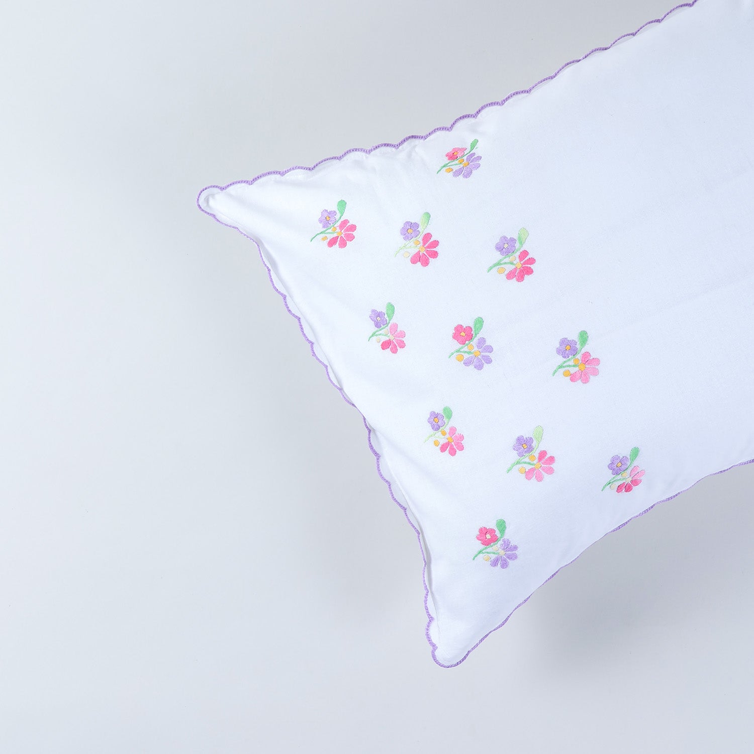 Close-up of handcrafted chikankari embroidery and scalloped edge detailing on cotton pillow cover