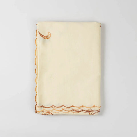 Folded view of a light brown embroidered bedcover set showcasing cotton fabric quality