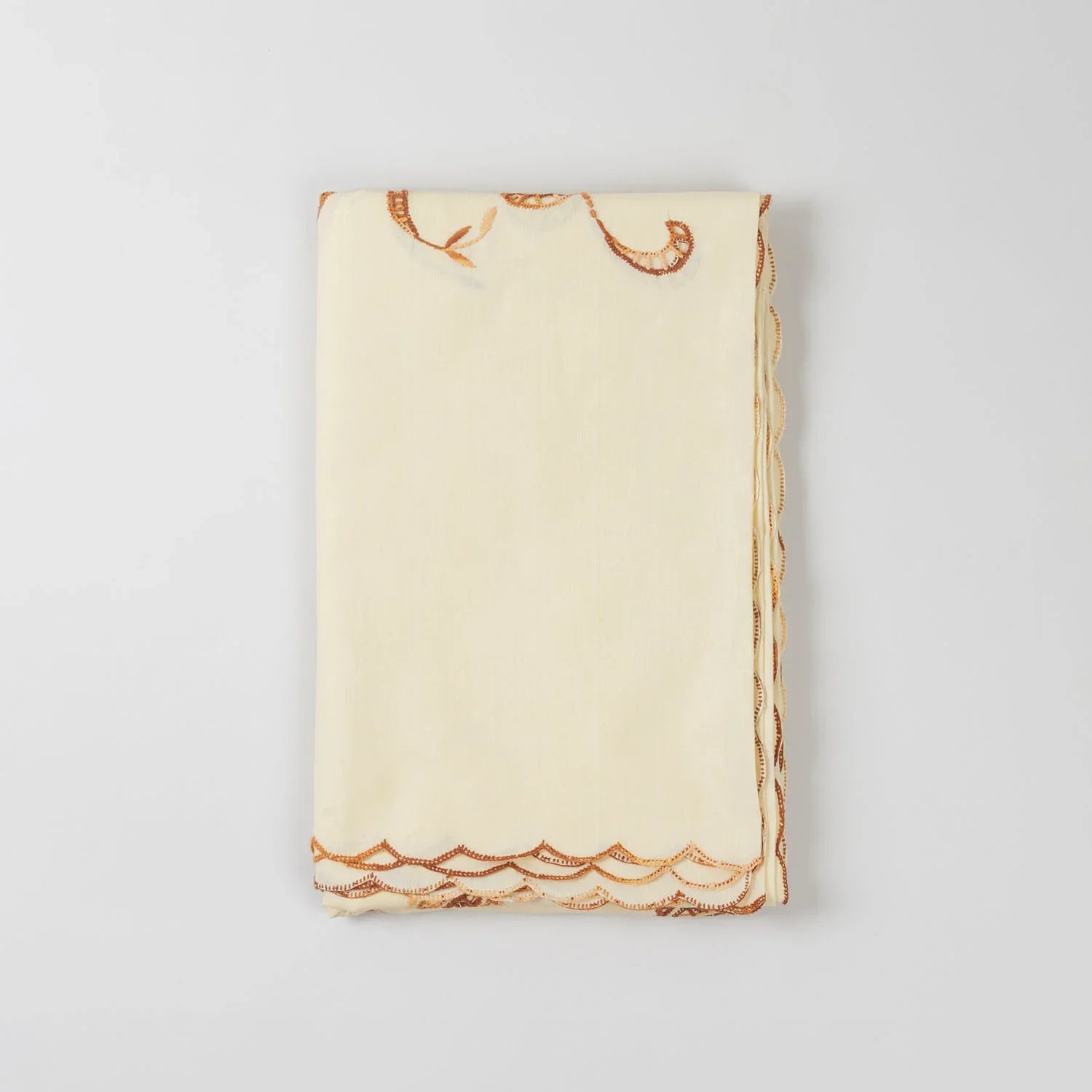 Folded light brown embroidered king-size bedcover showcasing fabric texture and handcrafted detailing