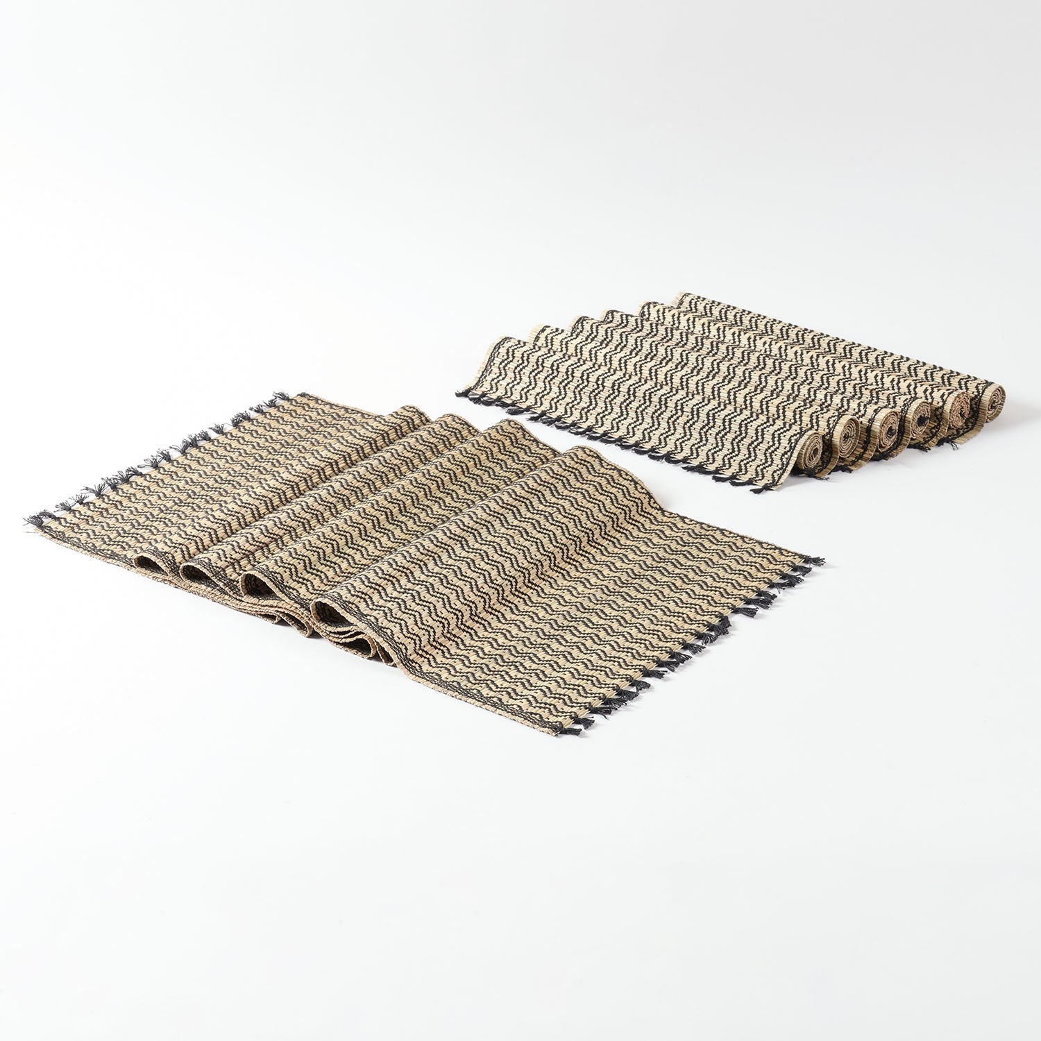 Handmade table runner and placemats set crafted from Madurkathi grass, showcasing natural fibre texture, black detailing, and fringe accents