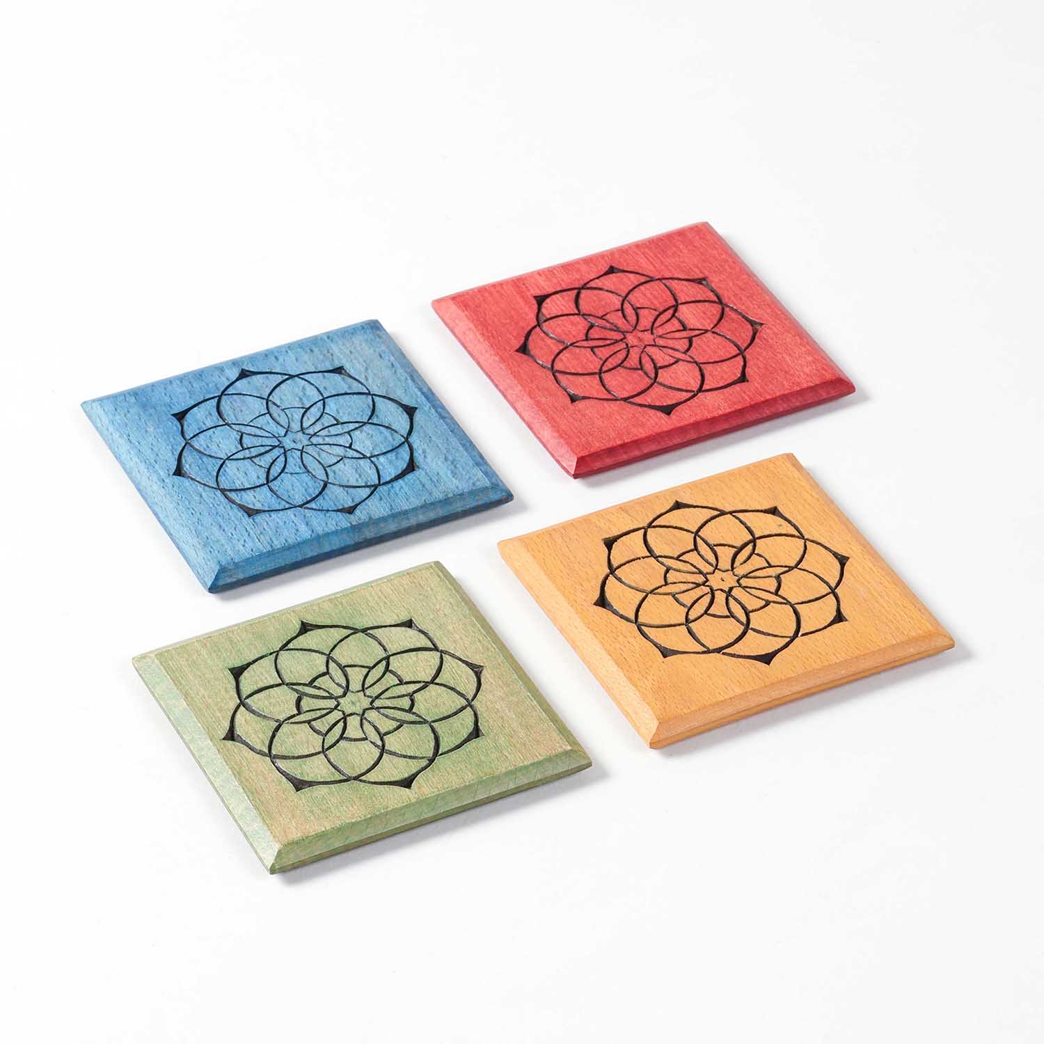 Angled view of the Mandala wooden coaster set of 4 showcasing the colourful handcrafted designs.
