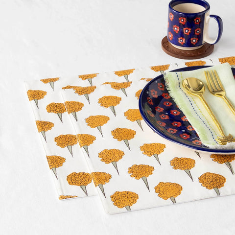 Marigold hand block printed cotton placemats styled on a dining table with tableware for a bright and inviting table setting