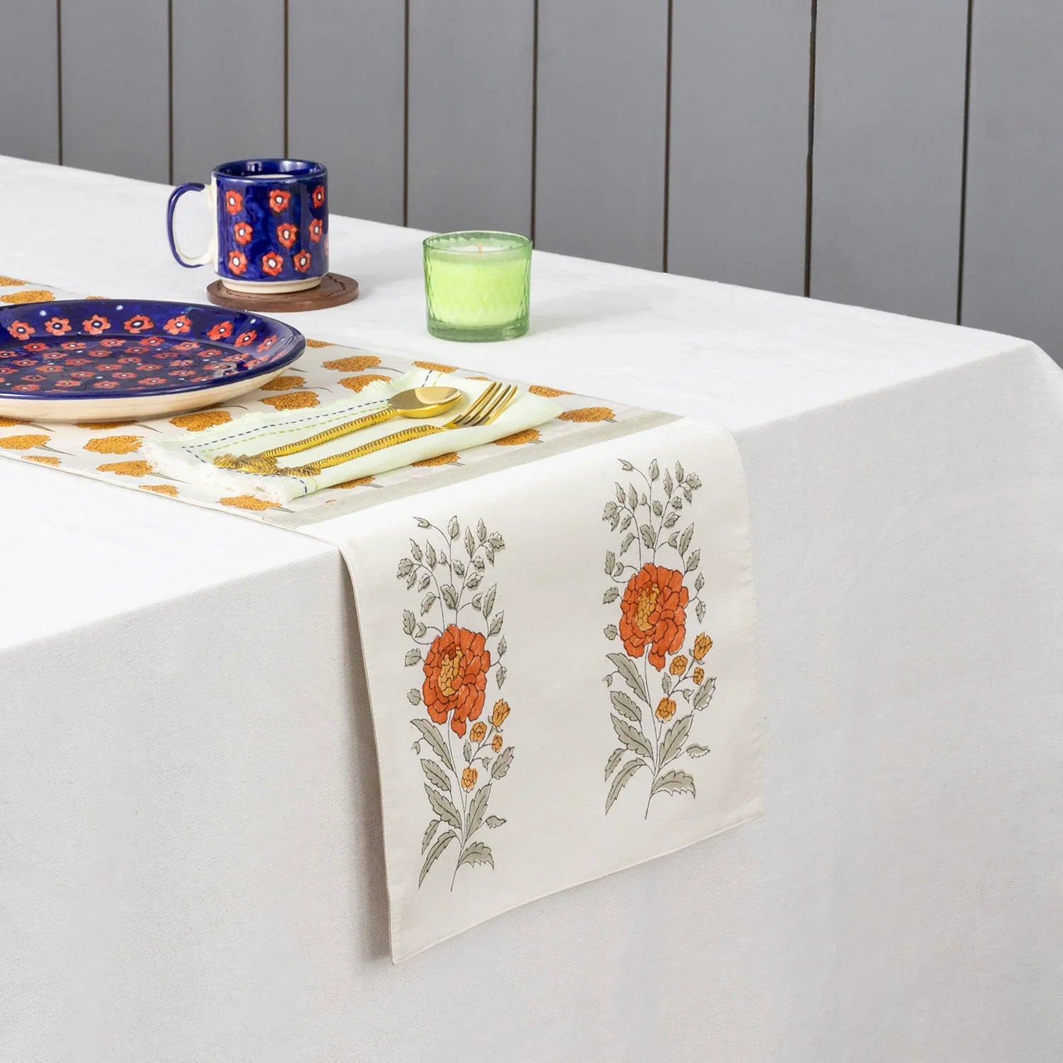 Marigold buta block printed Chanderi table runner styled on a dining table with coordinated tableware and festive decor accents