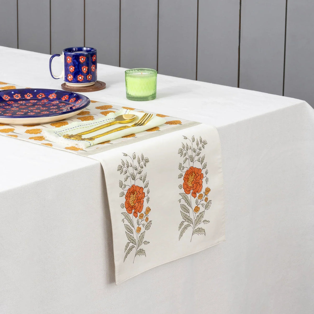 Marigold buta block printed Chanderi table runner styled on a dining table with coordinated tableware and festive decor accents