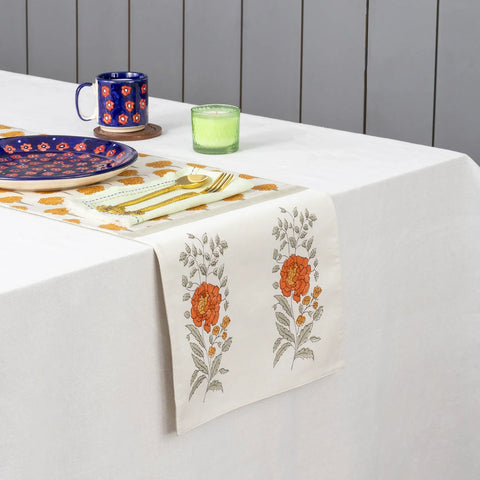 Marigold buta block printed Chanderi table runner styled on a dining table with coordinated tableware and festive decor accents