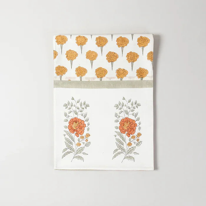 Folded Chanderi table runner featuring yellow and green marigold buta block printed motifs on an off-white base