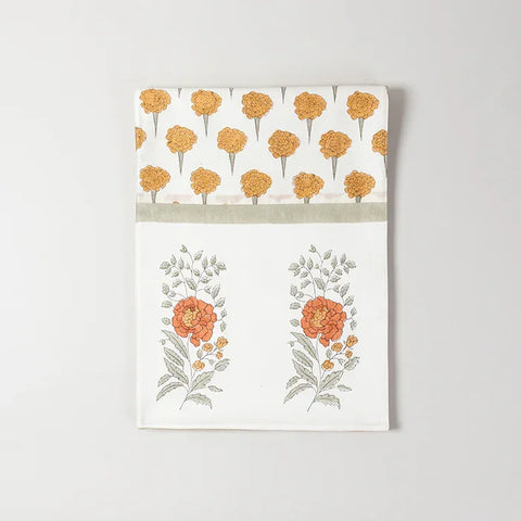 Folded Chanderi table runner featuring yellow and green marigold buta block printed motifs on an off-white base