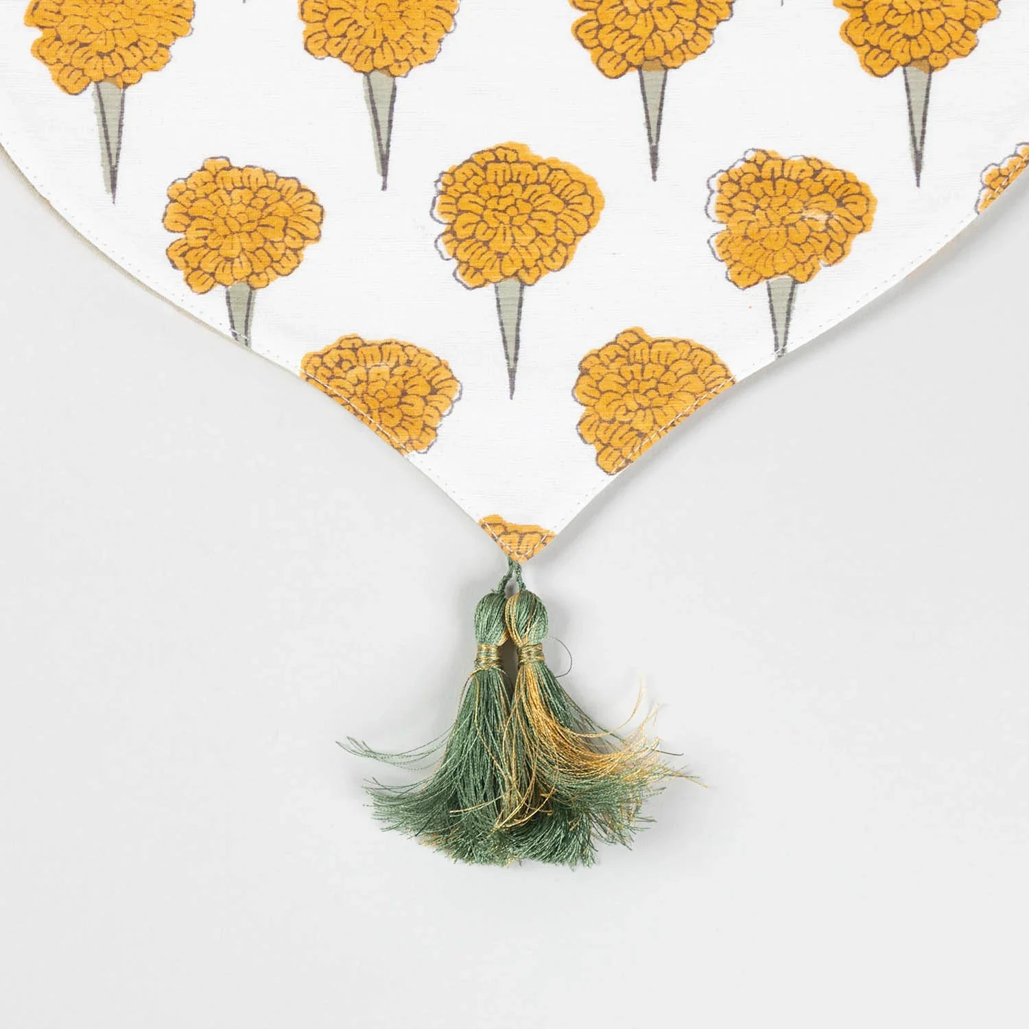 Close-up of the pointed V-shaped edge of a Marigold Buta Chanderi table runner finished with decorative tassels