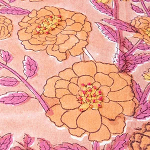 Close-up of marigold jaal floral block print in dark pink and orange on soft pink cotton cushion cover