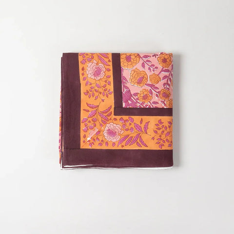 Detailed folded view of a pink hand block printed bedcover, highlighting marigold jaal motifs and cotton sheeting texture