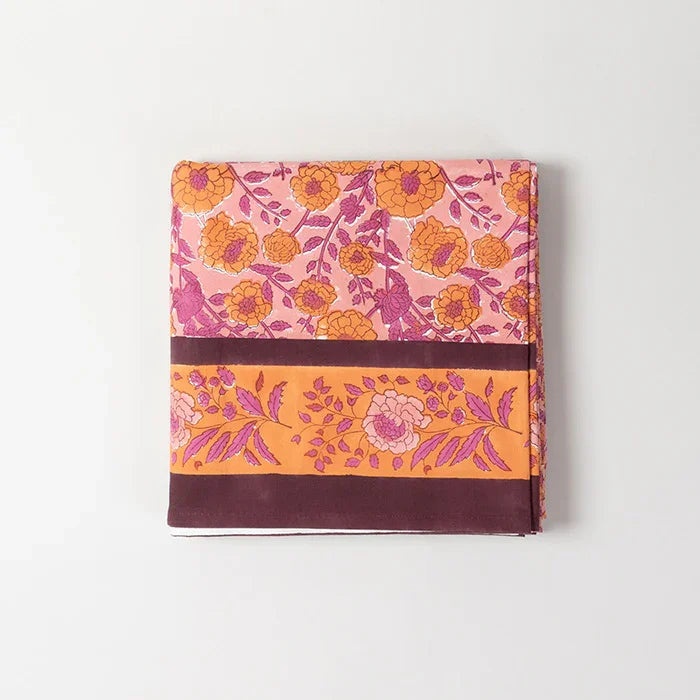 Folded pink cotton bedcover showcasing marigold jaal hand block printed patterns and fabric texture