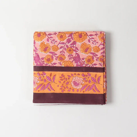Folded pink cotton bedcover showcasing marigold jaal hand block printed patterns and fabric texture