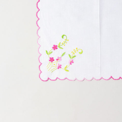 Close-up of multicolour floral embroidery on a white cotton napkin highlighting Bengal chikankari craftsmanship and intricate handwork