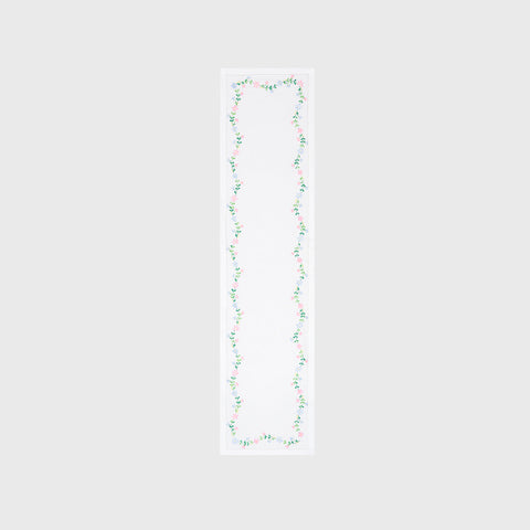 Full-length embroidered table runner featuring multicoloured floral vine motifs on a white cotton base displayed on a plain background