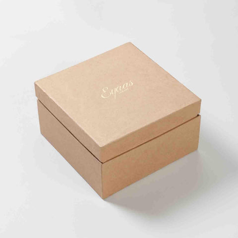 Angled view of a closed gift box containing a set of four textured glass tumblers