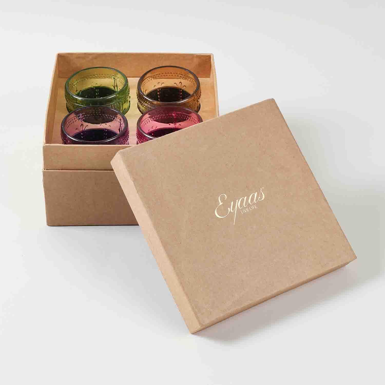 Open gift box displaying four multi-coloured textured glass tumblers ready for gifting