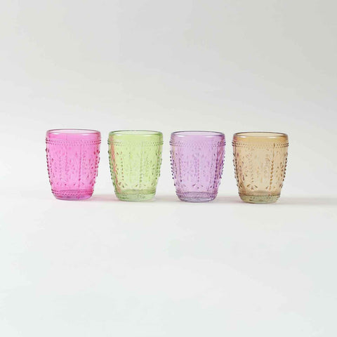 Set of four textured glass tumblers in green pink, lavender and beige displayed against a clean background