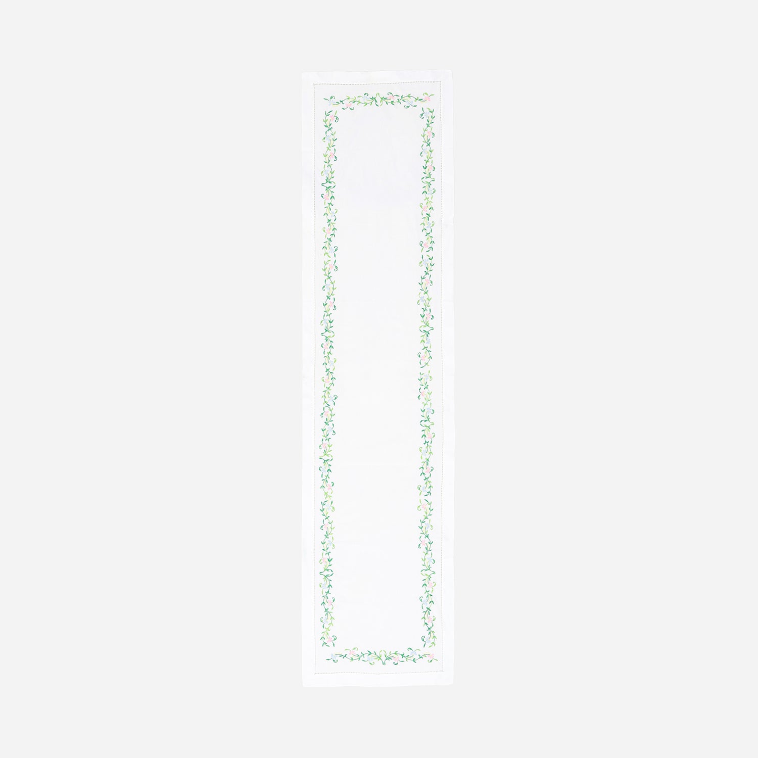 Full-length embroidered table runner featuring colourful floral vine motifs on a white cotton base displayed on a plain background