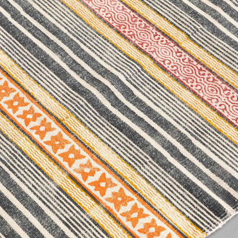 Close-up of geometric stripe hand block printed motifs on a multicolor cotton dhurrie highlighting artisan craftsmanship and texture
