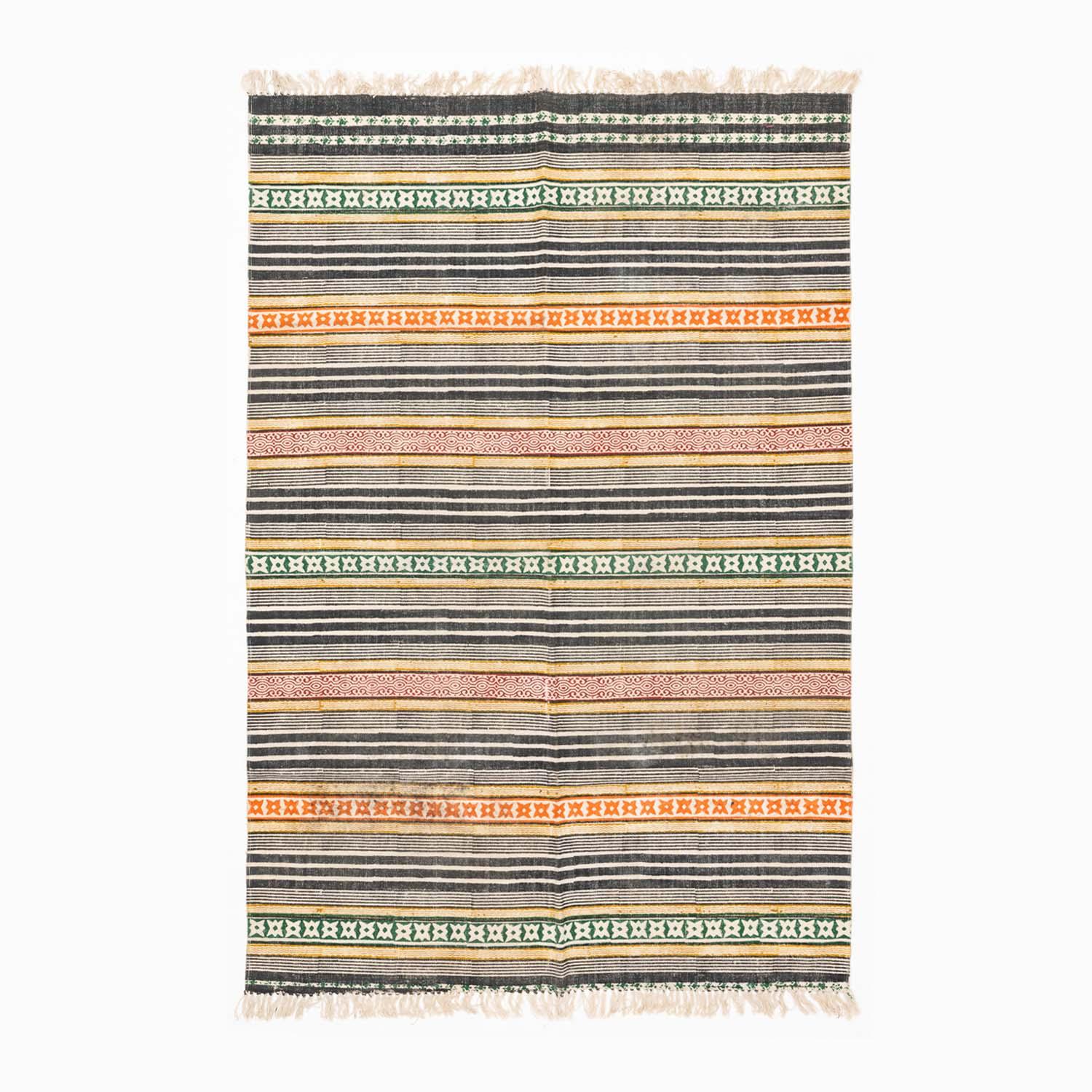 Handloom cotton rug featuring multicolor geometric stripes and block printed patterns in a contemporary design