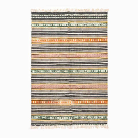 Handloom cotton rug featuring multicolor geometric stripes and block printed patterns in a contemporary design