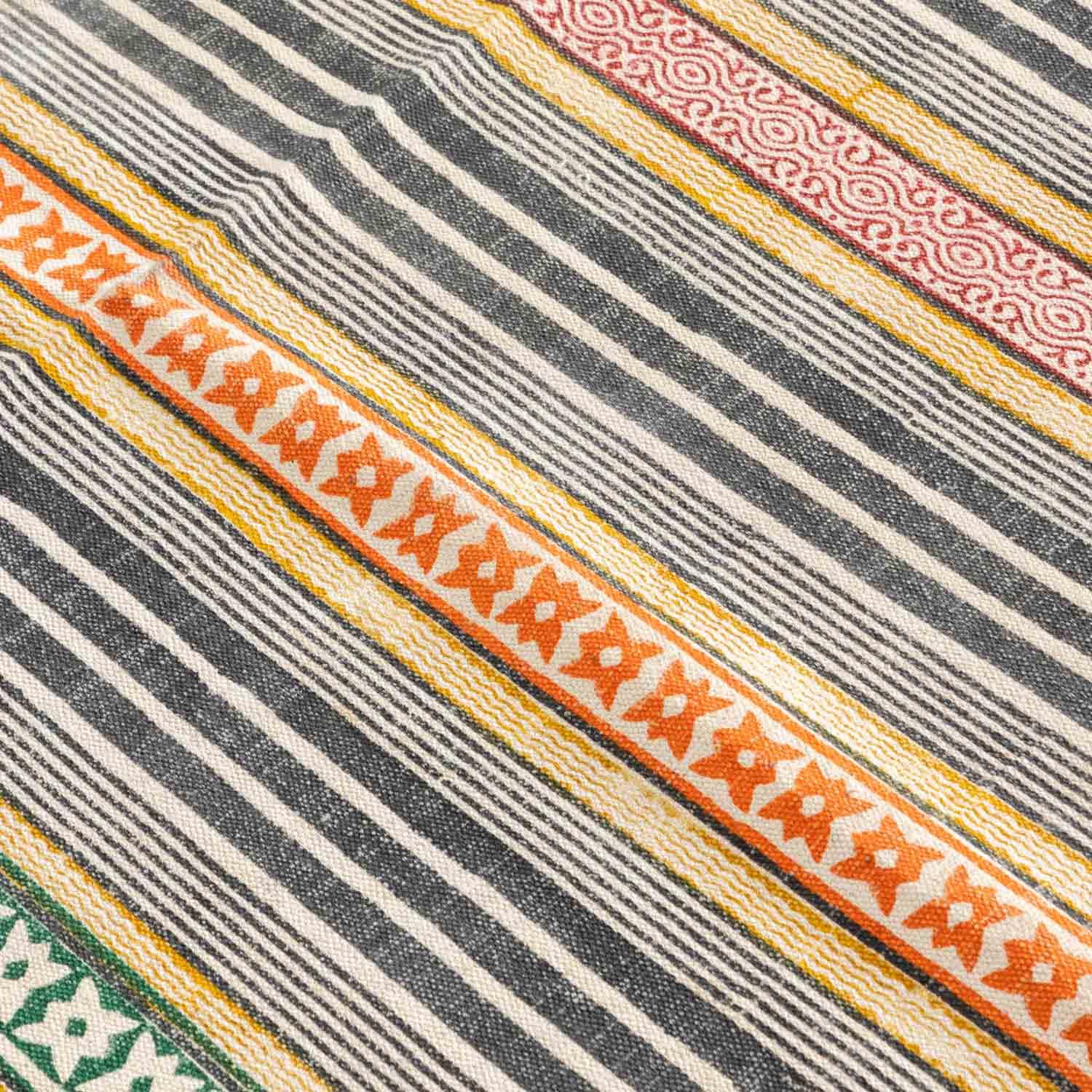 Close-up of geometric stripe motifs highlighting handloom weaving texture and block printed craftsmanship