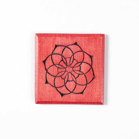 Set of multicoloured wooden table coasters featuring intricate mandala artwork.