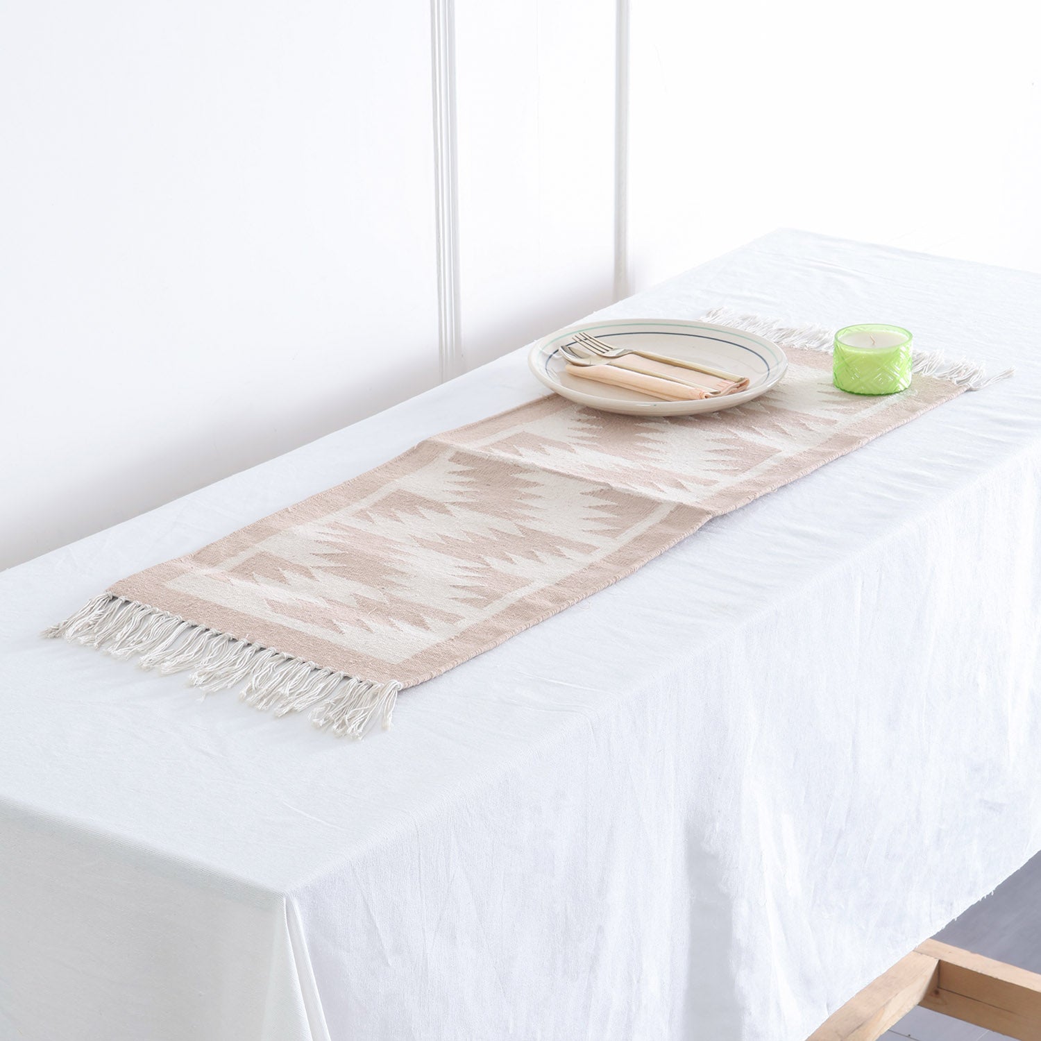 Off-white and beige geometric handwoven cotton floor cum table runner styled on a table as a minimalist home accent