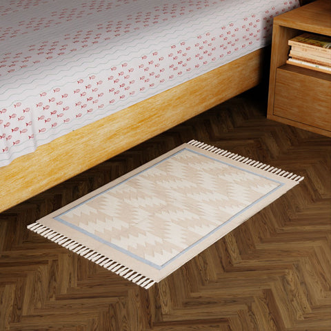 Off-white and beige geometric handwoven cotton dhurrie styled in a modern living space as an elegant floor accent