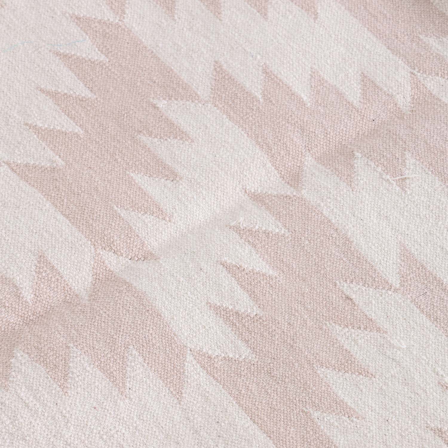 Close-up of geometric zigzag motifs and textured handwoven cotton weave on a Bikaner dhurrie
