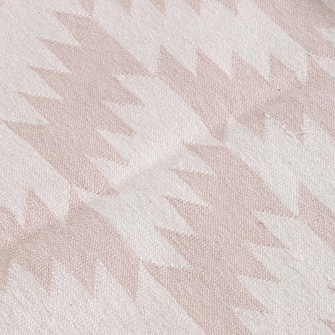 Close-up of geometric zigzag motifs and textured handwoven cotton weave on a Bikaner dhurrie