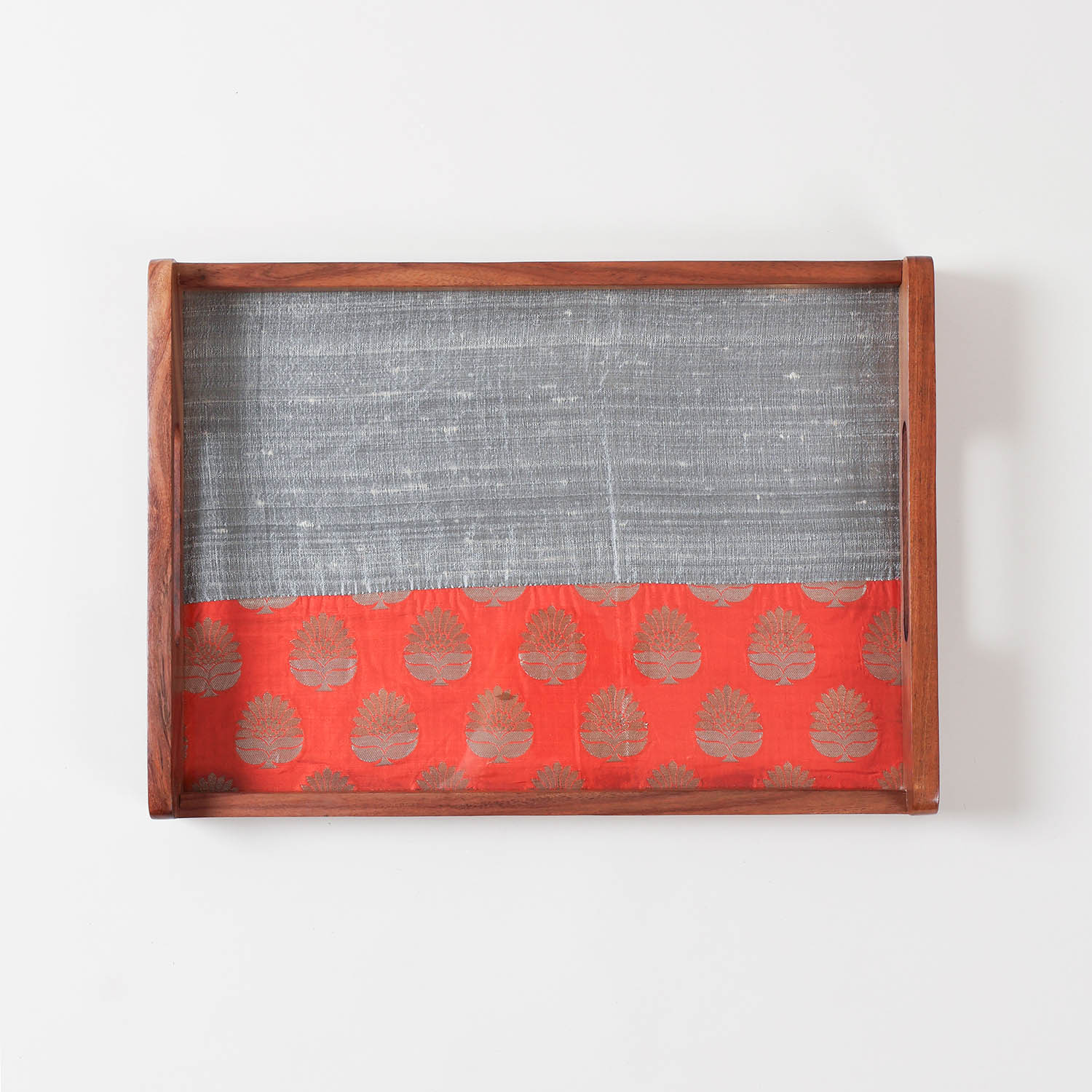 Top-view of glass-topped wooden tray highlighting dual fabric design with one solid and one golden paisley work underneath