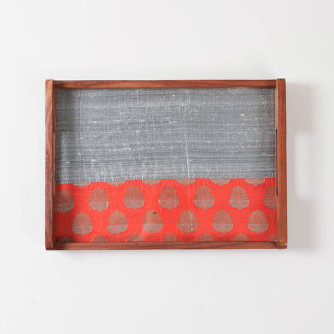 Top-view of glass-topped wooden tray highlighting dual fabric design with one solid and one golden paisley work underneath