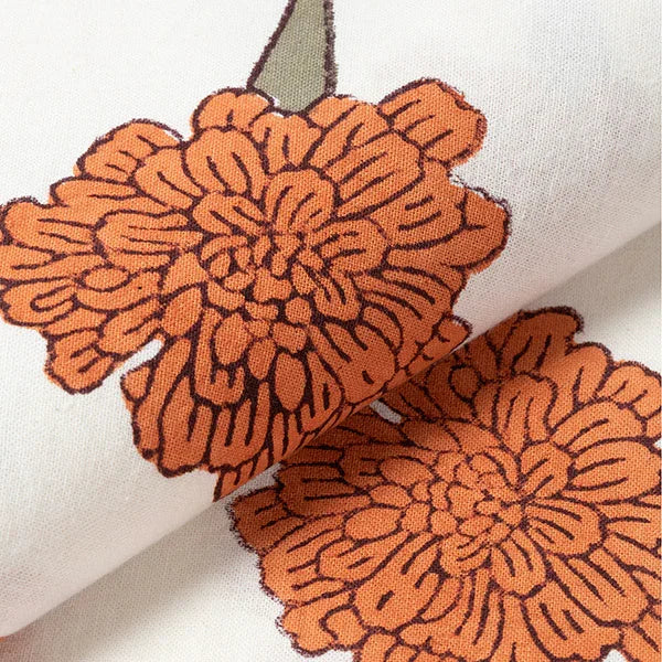 Close-up of orange marigold buti floral block print motifs on a handcrafted cotton table cloth