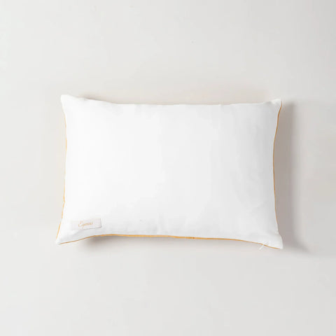 Back view of an orange marigold buta block printed lumbar cushion cover displaying a solid white back side