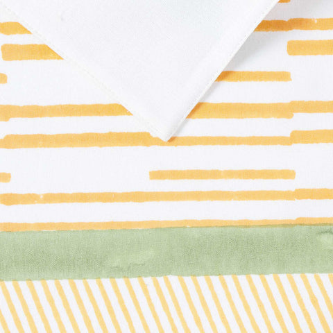 Close-up of orange line and dash motifs with green border accents on cotton table placemat