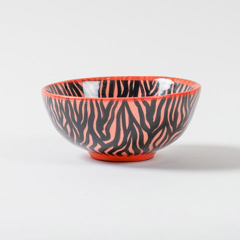 Handmade African ceramic bowl featuring a striking black zebra stripe pattern on an orange base, suitable as a snack bowl, salad bowl, or decorative tableware piece